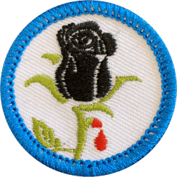 A embroidered badge featuring a black rose with a drop of red blood on a white background, bordered.