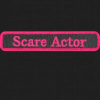 Security Name Badge with "Scare Actor" text in pink embroidery on black fabric.