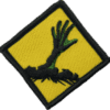 Zombie hand patch with green fingers on yellow background.