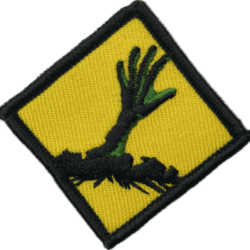 Zombie hand patch with green fingers on yellow background.