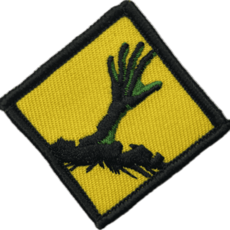 Zombie hand patch with green fingers on yellow background.